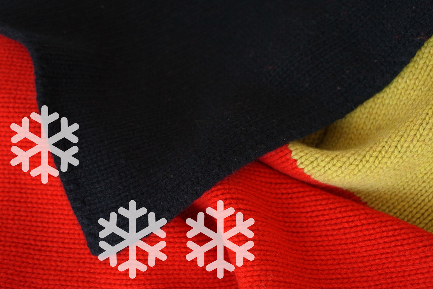 Close-up of a black, red, and yellow fabric with snowflake graphics