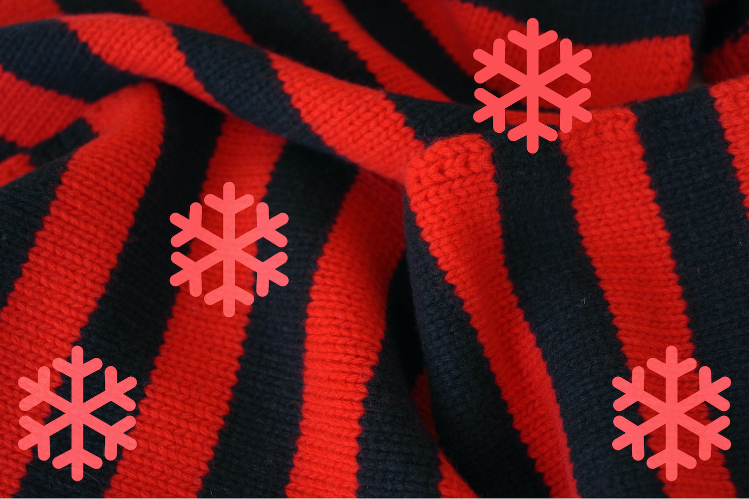 Close-up of red and black striped fabric with red snowflakes.
