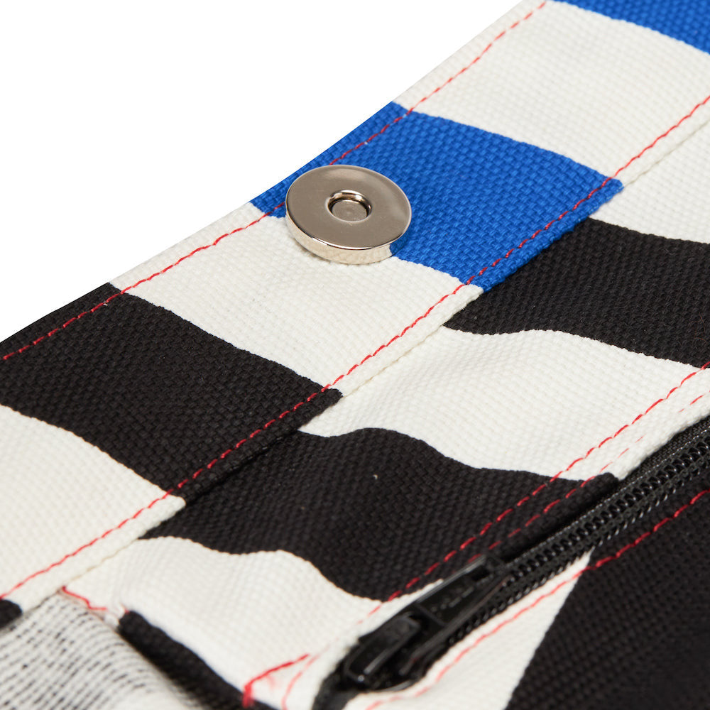 Close-up of a fabric with black, white, and blue stripes featuring a zipper.