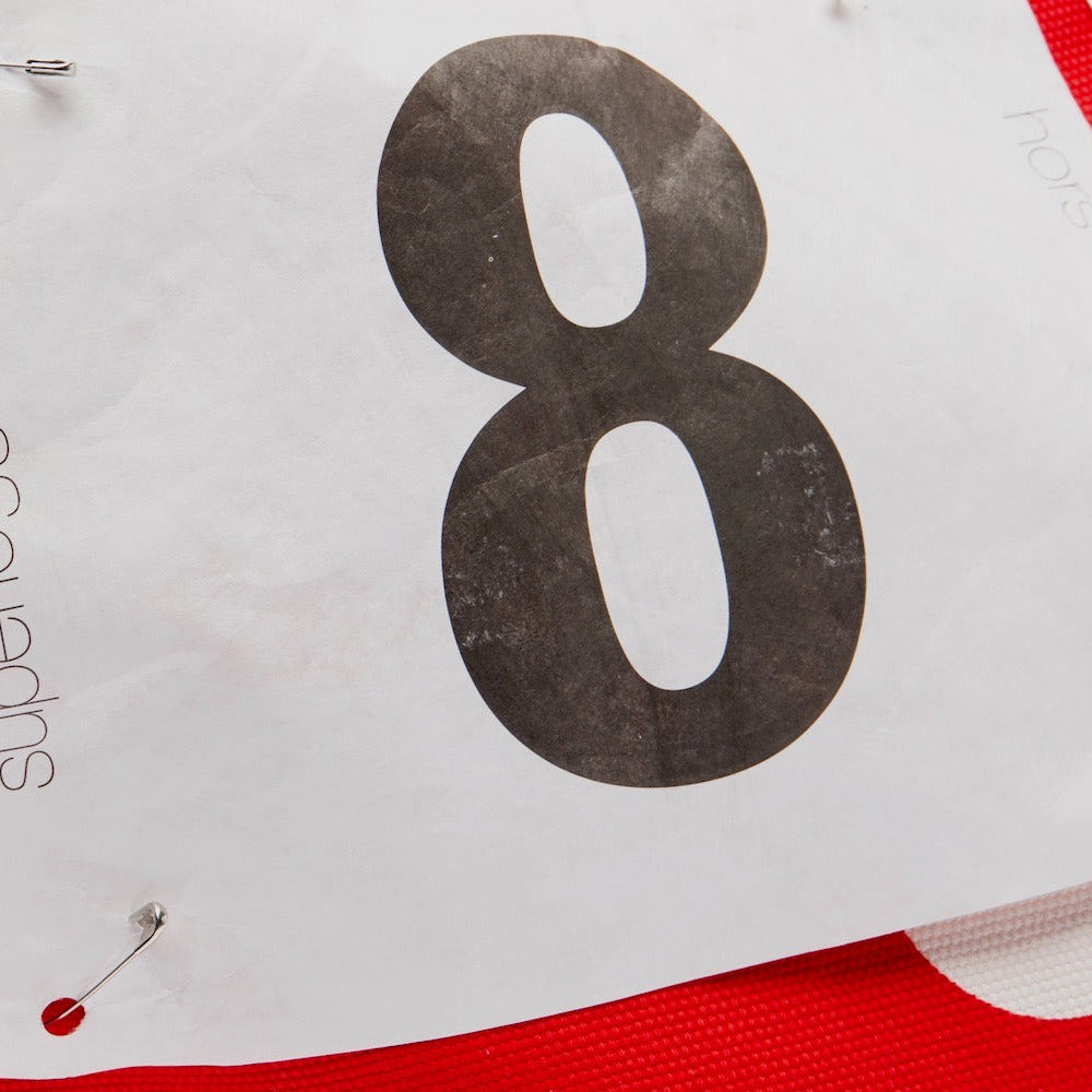 Large number '8' printed on a white background with red accents.