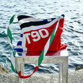 Colorful bag with 'T90' branding on a chair by the water