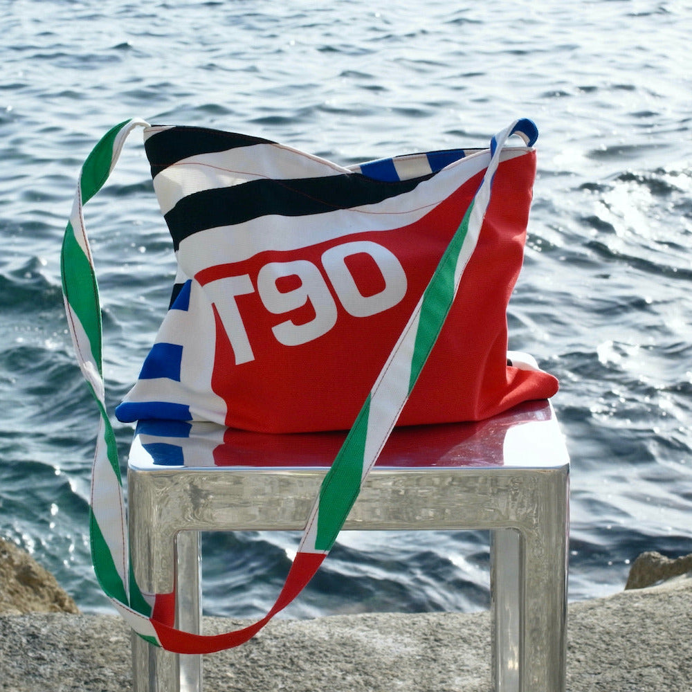 Colorful bag with 'T90' branding on a chair by the water