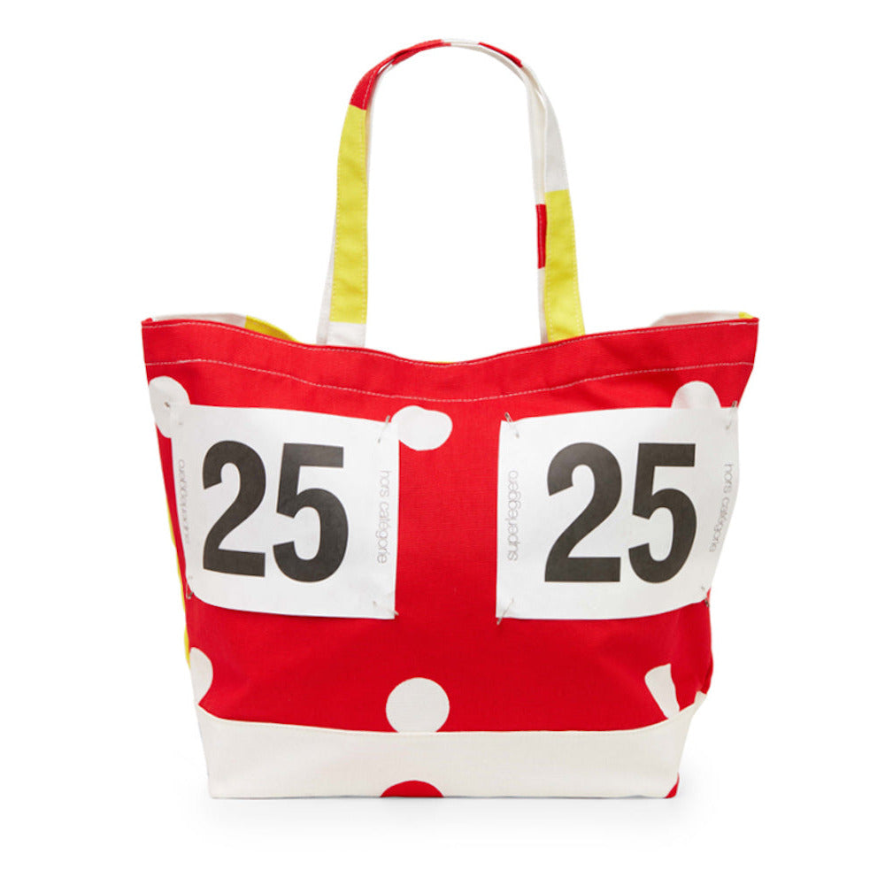 Red tote bag with white polka dots and black number '25' on a white background